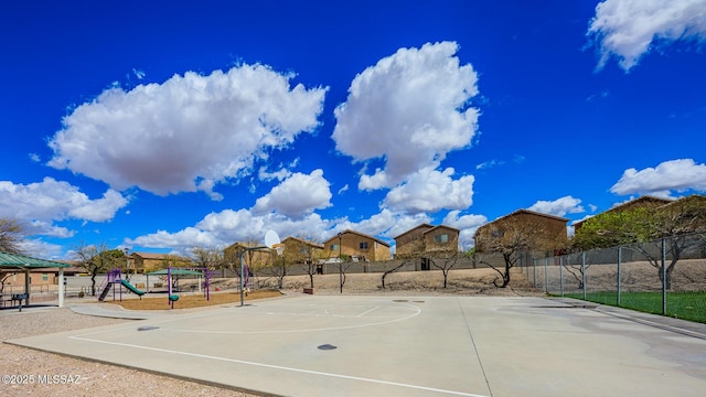 view of sport court with community basketball court, fence, and playground community