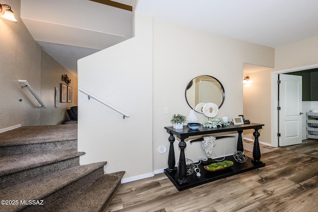 stairs featuring wood finished floors and baseboards