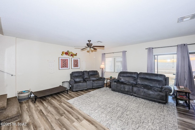 living area with wood finished floors, visible vents, and ceiling fan