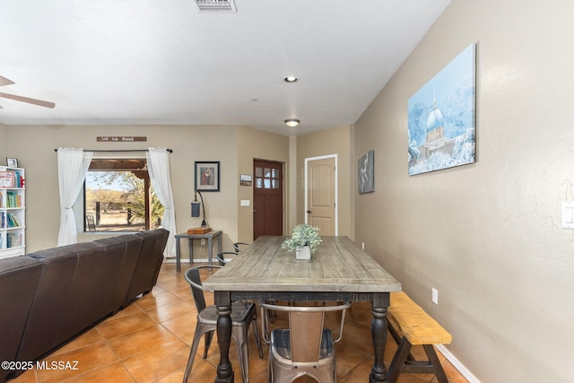 dining space featuring light tile patterned flooring, baseboards, and ceiling fan