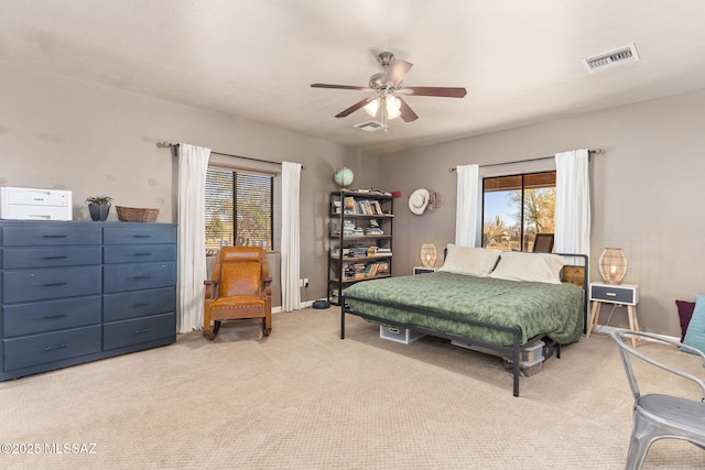 carpeted bedroom with a ceiling fan, visible vents, and baseboards