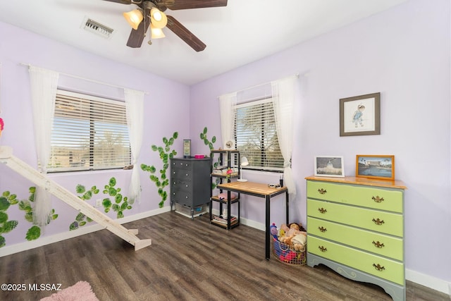 home office featuring a wealth of natural light, visible vents, a ceiling fan, and dark wood-style floors