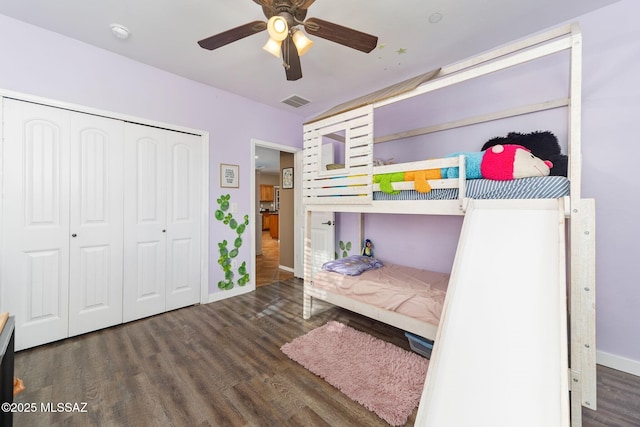 unfurnished bedroom with a ceiling fan, visible vents, wood finished floors, baseboards, and a closet