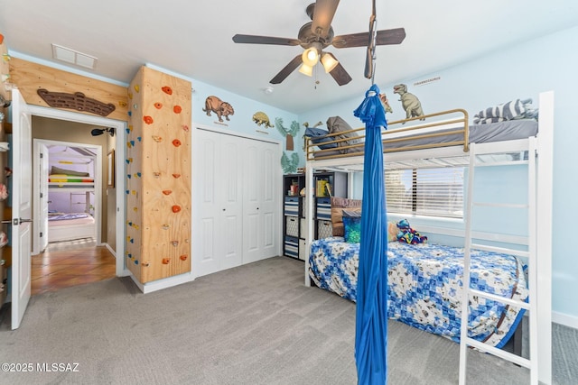 bedroom featuring a closet, a ceiling fan, visible vents, and carpet floors