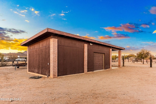 garage at dusk with a detached garage