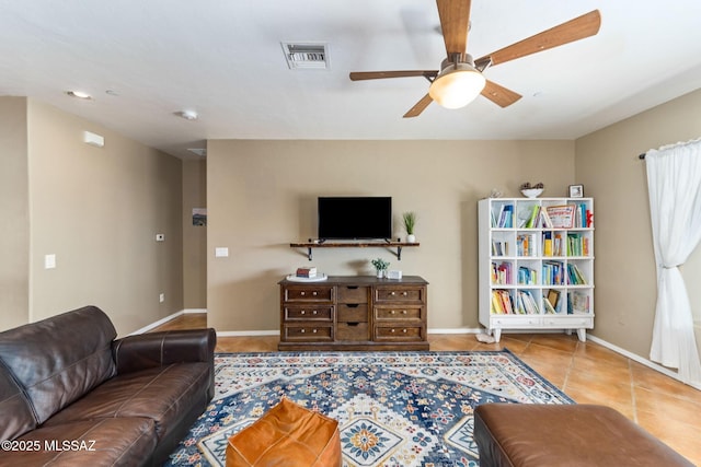 tiled living area featuring a ceiling fan, visible vents, and baseboards