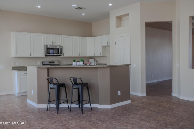 kitchen with a sink, white cabinetry, appliances with stainless steel finishes, and a healthy amount of sunlight