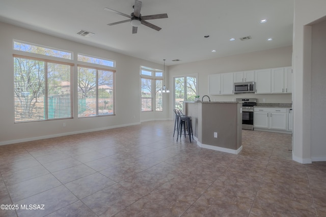 kitchen with light stone counters, a ceiling fan, stainless steel dishwasher, a sink, and white cabinetry