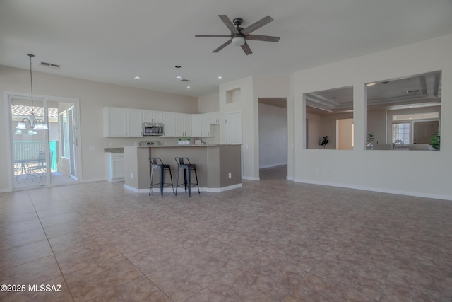 kitchen featuring light tile patterned floors, stainless steel appliances, white cabinets, light stone countertops, and recessed lighting