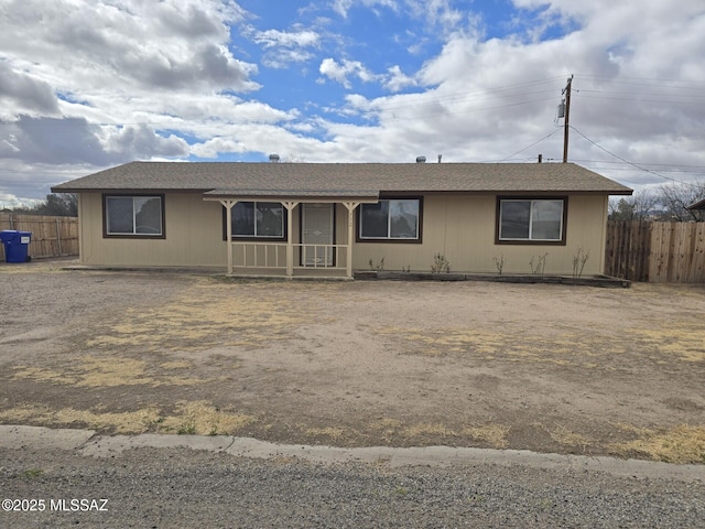 ranch-style home featuring fence