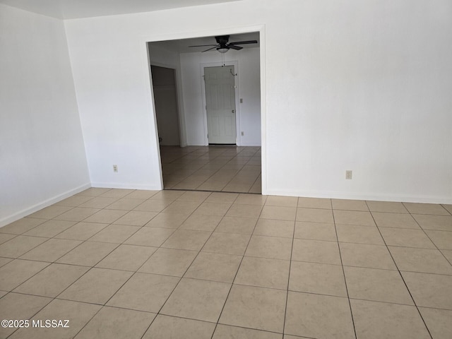 unfurnished room featuring light tile patterned flooring, a ceiling fan, and baseboards