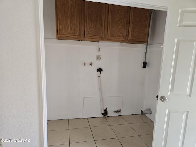 laundry area featuring hookup for a gas dryer, cabinet space, and light tile patterned flooring