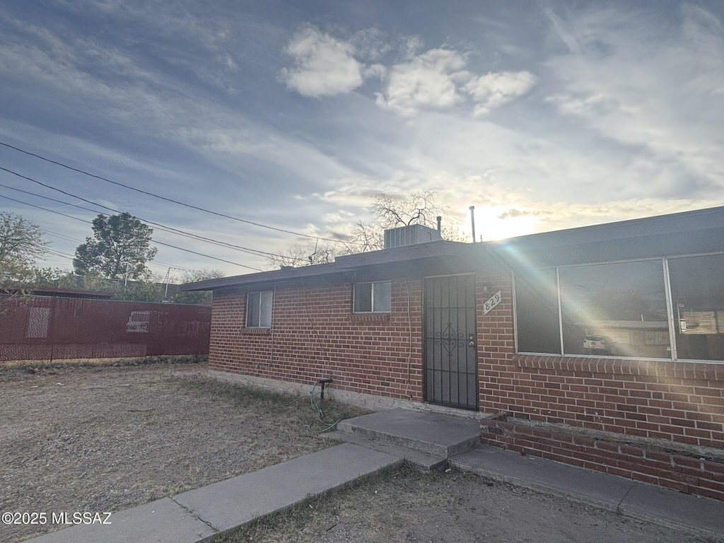 exterior space featuring brick siding and fence