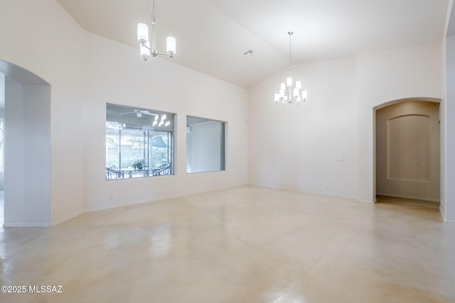 empty room with high vaulted ceiling, arched walkways, an inviting chandelier, baseboards, and concrete flooring