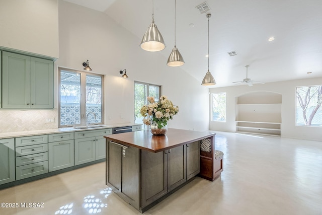 kitchen featuring visible vents, built in shelves, green cabinets, arched walkways, and a sink