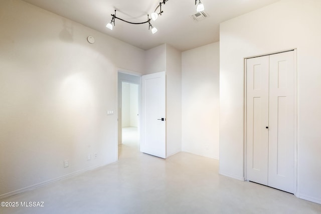 interior space featuring visible vents, rail lighting, finished concrete flooring, and baseboards