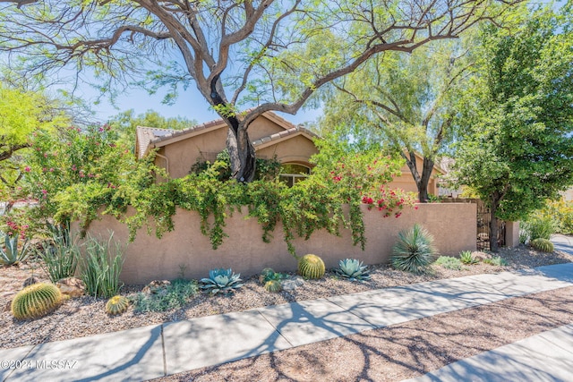 view of front of property with a fenced front yard, stucco siding, and a tile roof