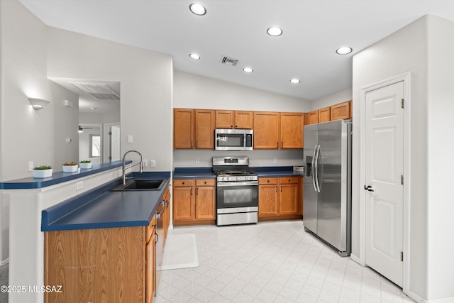 kitchen featuring visible vents, a sink, dark countertops, stainless steel appliances, and light floors