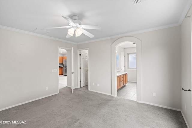 unfurnished bedroom featuring carpet floors, arched walkways, and crown molding