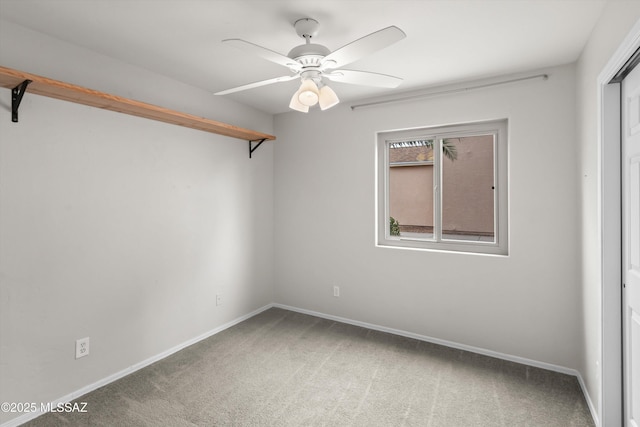 carpeted empty room featuring baseboards and ceiling fan