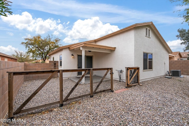 rear view of property featuring a patio area, stucco siding, cooling unit, and a fenced backyard