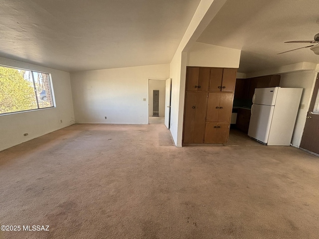 unfurnished living room featuring light colored carpet and ceiling fan