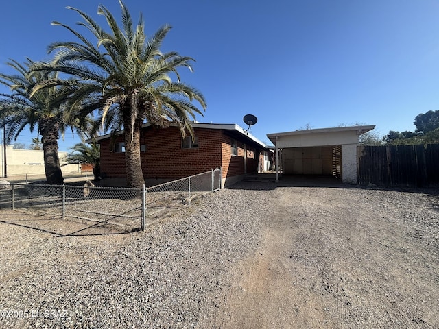 view of property exterior featuring gravel driveway and fence