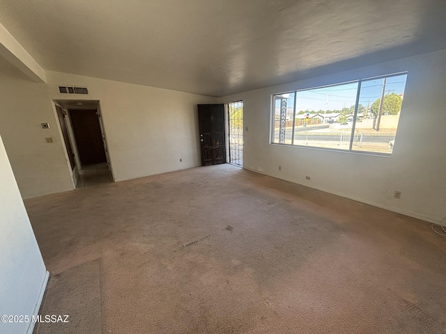 empty room featuring visible vents and carpet floors