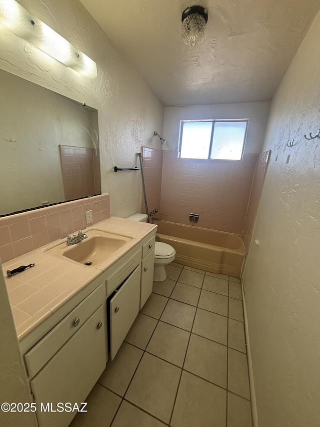 full bath featuring toilet, bathtub / shower combination, a textured wall, tile patterned floors, and vanity