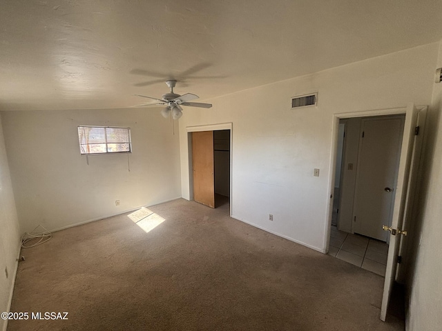 unfurnished bedroom with visible vents, carpet, a closet, and a ceiling fan