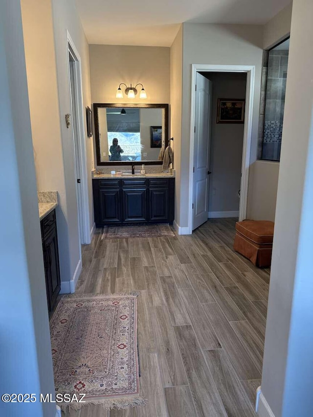 bathroom featuring baseboards, wood finished floors, and vanity