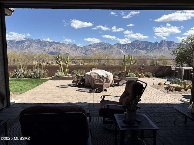 view of patio featuring a mountain view and a fenced backyard