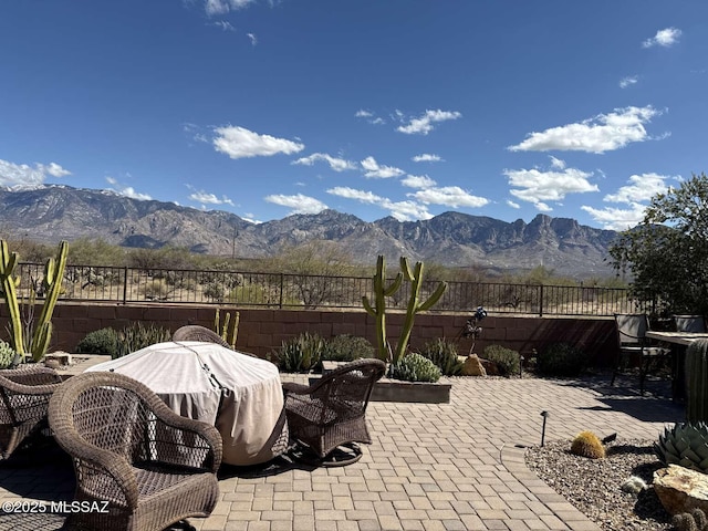 view of patio featuring area for grilling, a mountain view, and fence