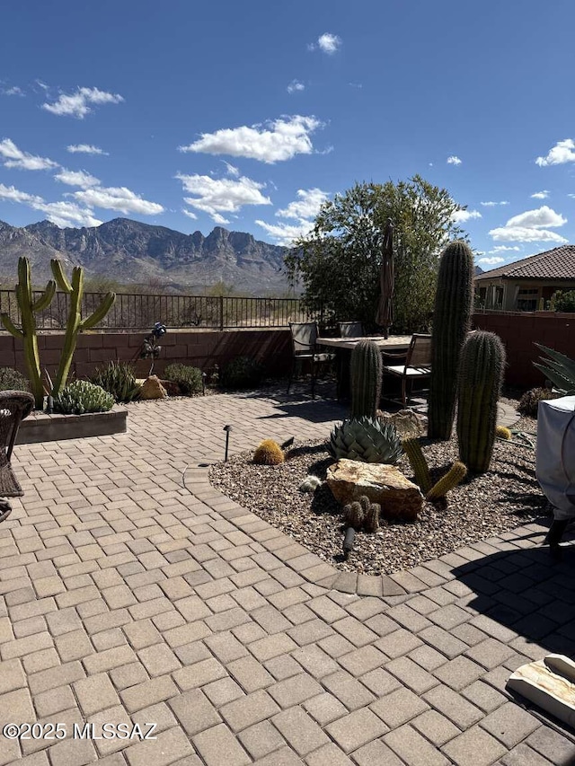 view of patio / terrace featuring a mountain view, outdoor dining space, and fence