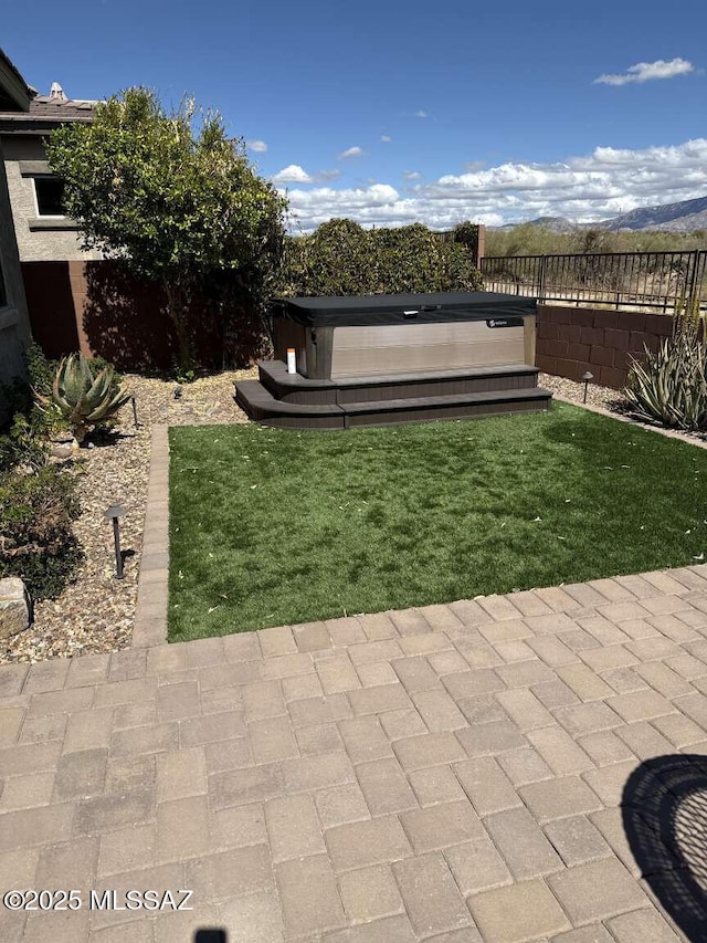 view of yard with fence and a hot tub