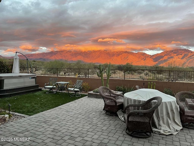 view of patio / terrace featuring a mountain view, a hot tub, and fence