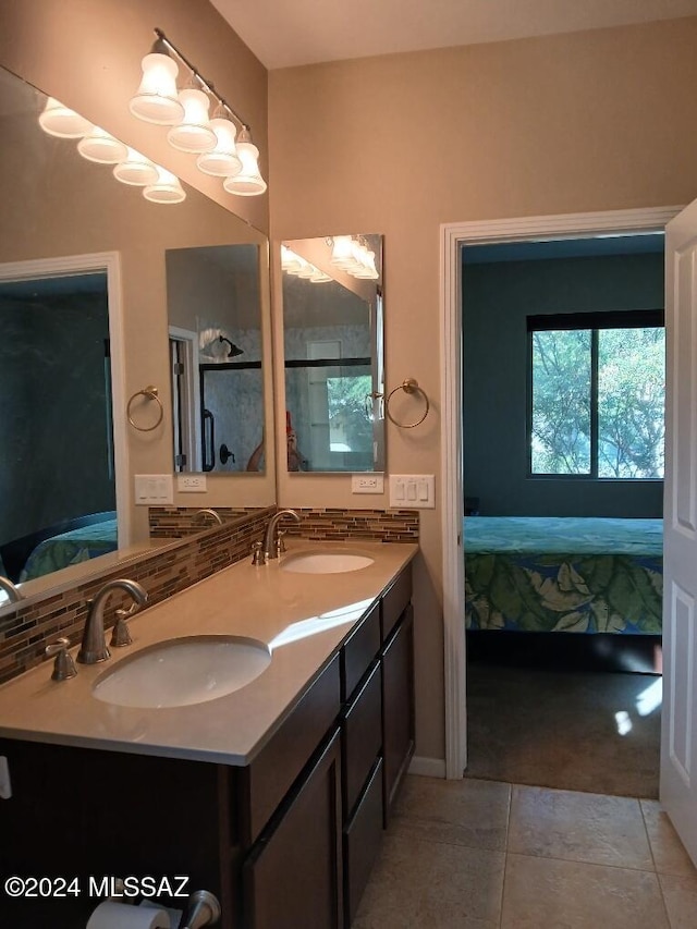 ensuite bathroom with a sink, double vanity, tasteful backsplash, and connected bathroom