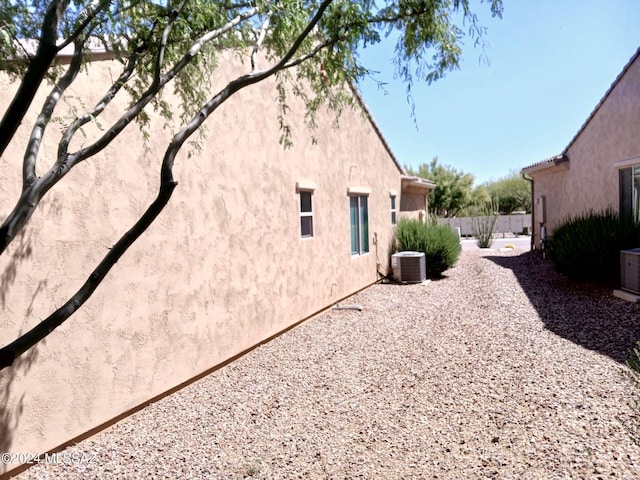 rear view of house featuring cooling unit and stucco siding