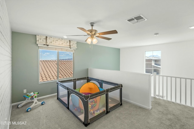 carpeted bedroom with visible vents, a ceiling fan, and baseboards