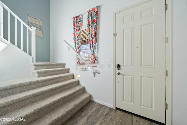 foyer with stairway, baseboards, and dark wood-style flooring