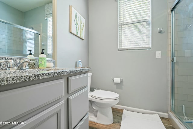 full bathroom featuring a shower stall, toilet, wood finished floors, and baseboards