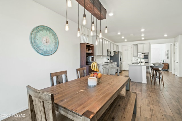 dining space featuring recessed lighting, light wood-type flooring, and baseboards