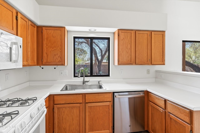 kitchen featuring white appliances, light countertops, and a sink