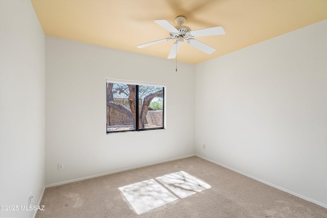 carpeted empty room with baseboards and ceiling fan