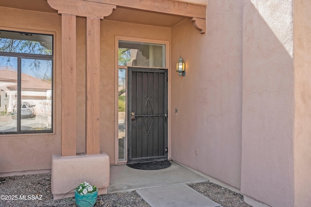 entrance to property featuring stucco siding