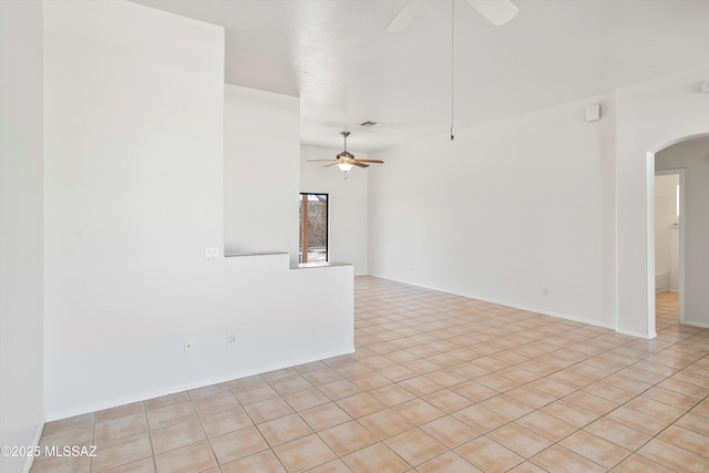 spare room with arched walkways and ceiling fan