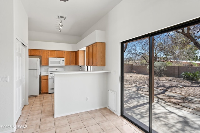 kitchen featuring white appliances, light tile patterned floors, light countertops, and brown cabinets