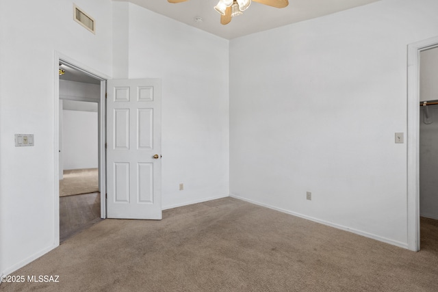 carpeted empty room featuring visible vents, baseboards, and ceiling fan