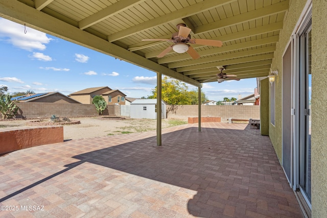 view of patio / terrace featuring an outdoor structure, a shed, a ceiling fan, and a fenced backyard