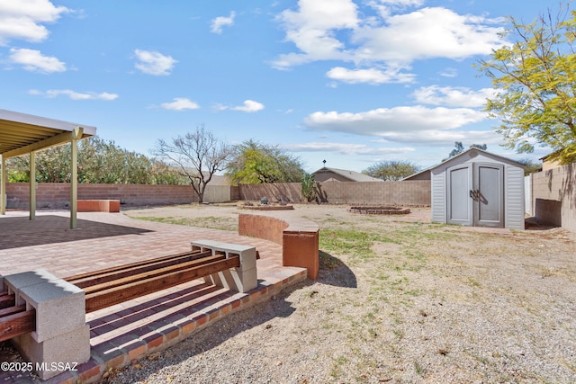 view of yard featuring a storage shed, a fenced backyard, an outdoor structure, and a patio